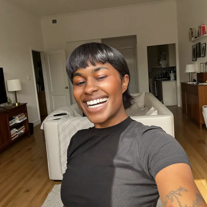 Person at home in the UK smiling and taking a photo of their teeth to start the process